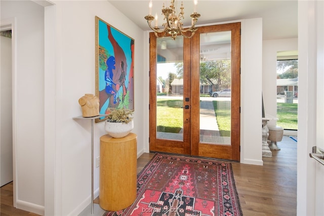 doorway with hardwood / wood-style floors, a notable chandelier, and french doors