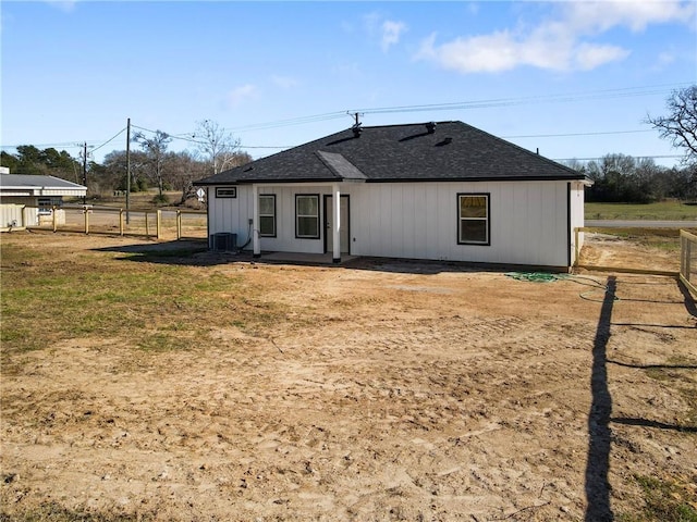 back of property with central AC and a yard