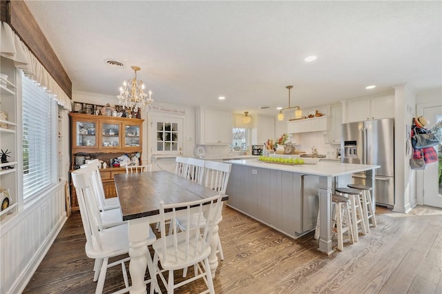 dining area with an inviting chandelier, a wealth of natural light, and light wood-type flooring