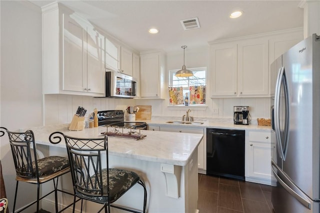 kitchen featuring hanging light fixtures, white cabinetry, a breakfast bar area, and black appliances