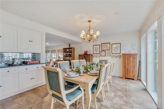 dining space featuring light parquet floors and a chandelier