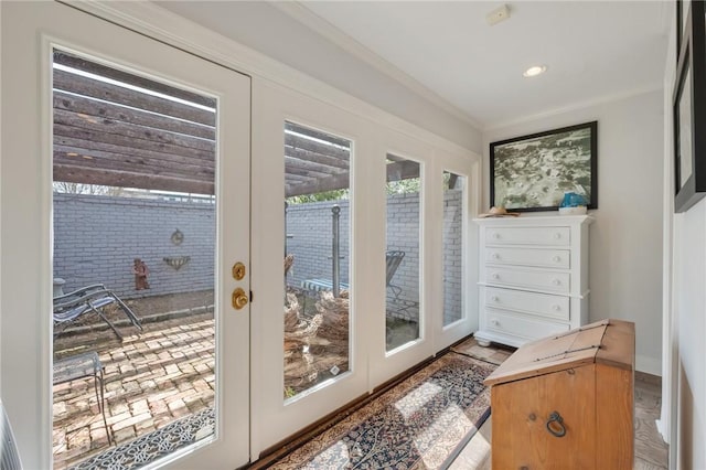 doorway to outside with crown molding and french doors