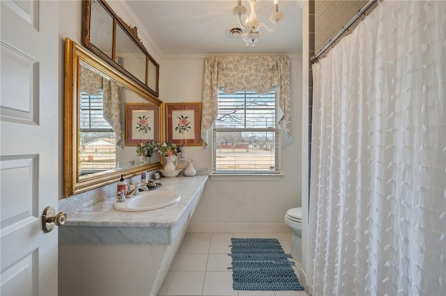 bathroom with crown molding, sink, a wealth of natural light, and tile patterned floors