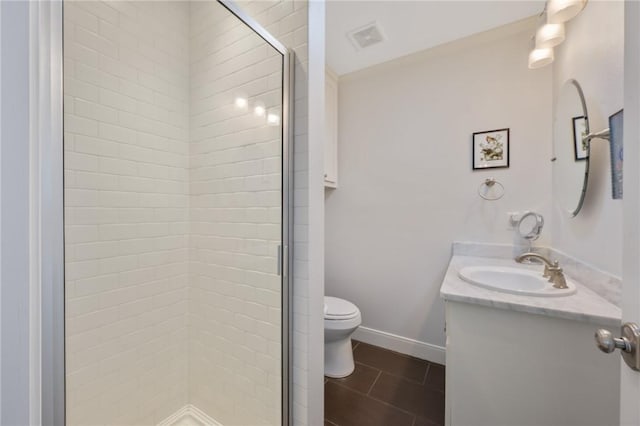 bathroom featuring tile patterned floors, vanity, toilet, and a shower with door