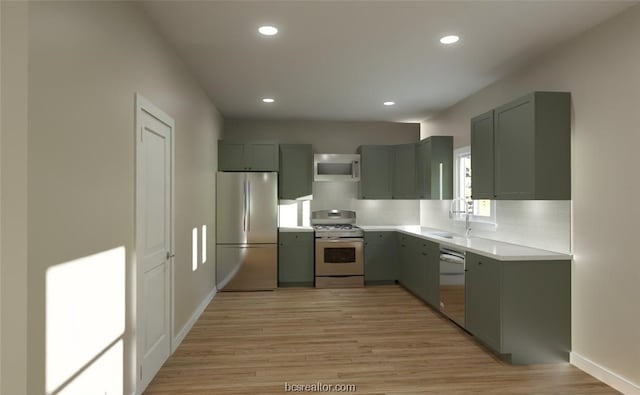 kitchen with backsplash, sink, light hardwood / wood-style flooring, and appliances with stainless steel finishes