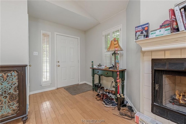2308 Carnation Ct, College Station, TX 77840 - entrance foyer featuring hardwood / wood-style flooring, a fireplace, lofted ceiling, healthy amount of natural light, and baseboards