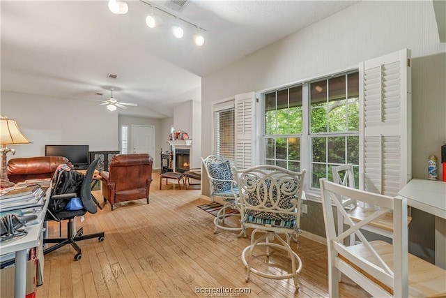 2308 Carnation Ct, College Station, TX 77840 - home office with track lighting, a warm lit fireplace, plenty of natural light, and ceiling fan