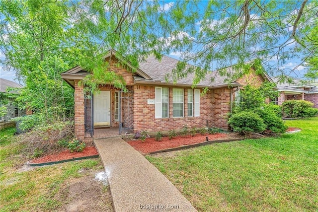 2308 Carnation Ct, College Station, TX 77840 - view of front of property with brick siding, a front lawn, and roof with shingles