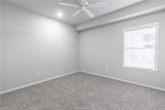 spare room with ceiling fan and carpet