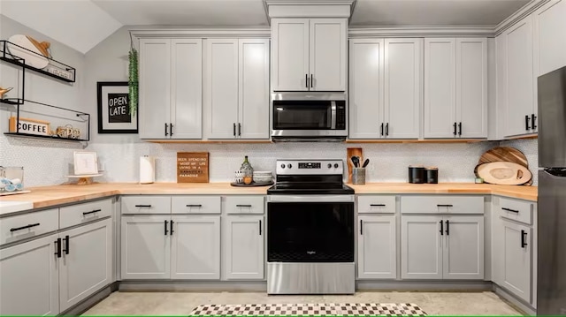 301 W 31st St Unit 103, Bryan, TX 77803 - kitchen featuring tasteful backsplash, butcher block counters, vaulted ceiling, and stainless steel appliances