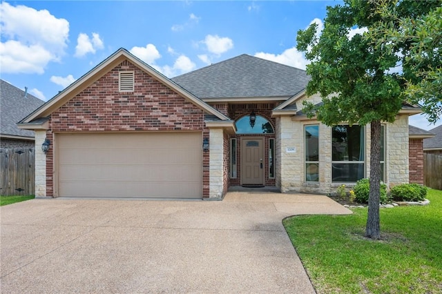 1208 Robinsville Ct, College Station, TX 77845 - french country inspired facade featuring roof with shingles, concrete driveway, a garage, brick siding, and stone siding