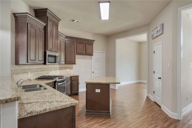 1208 Robinsville Ct, College Station, TX 77845 - kitchen with stainless steel appliances, a sink, decorative backsplash, and dark wood-style flooring