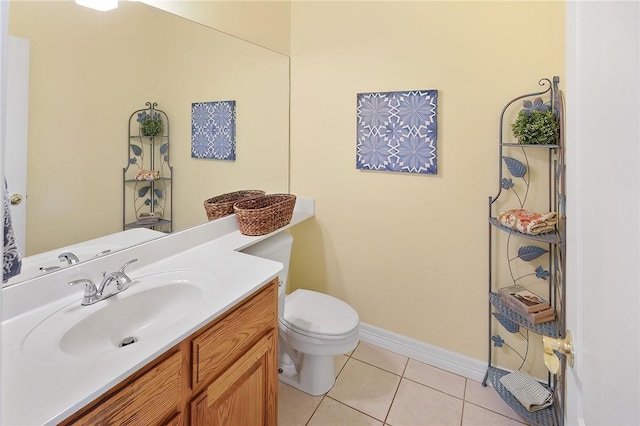 bathroom with toilet, vanity, and tile patterned floors