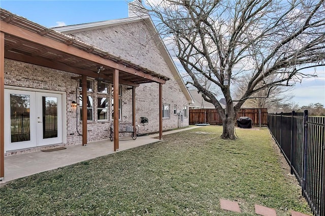 view of yard featuring ceiling fan, a patio area, and french doors