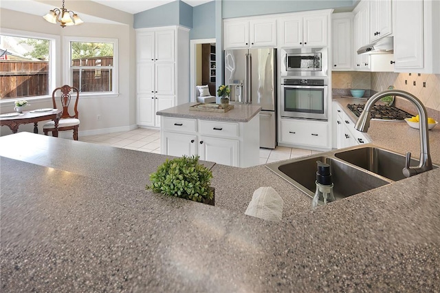 kitchen featuring backsplash, a notable chandelier, sink, white cabinetry, and stainless steel appliances