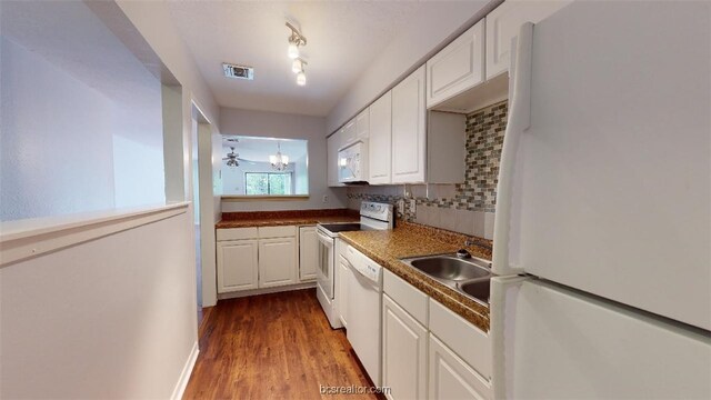 kitchen featuring white appliances, white cabinets, visible vents, wood finished floors, and backsplash