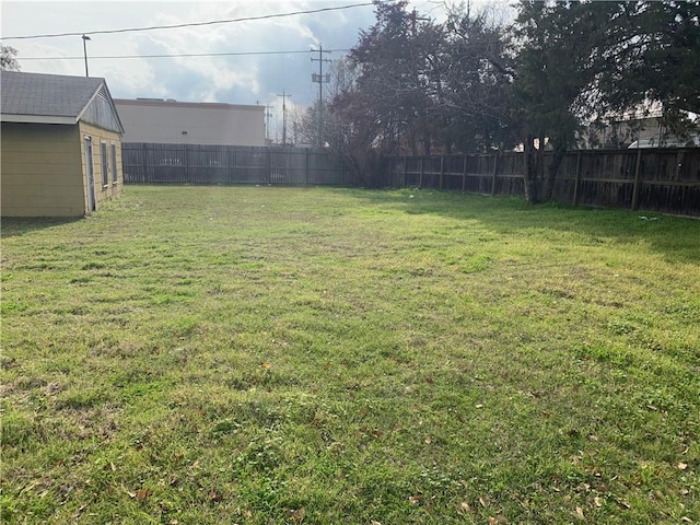 view of yard featuring a fenced backyard, an outdoor structure, and a storage shed