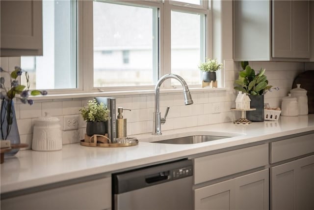 kitchen with dishwasher, sink, decorative backsplash, and gray cabinetry