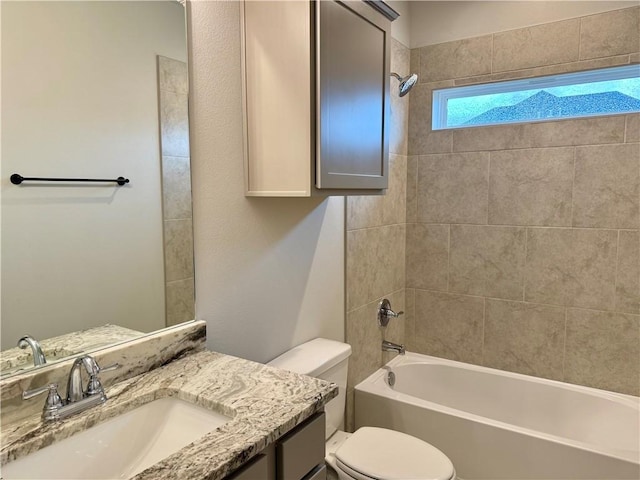 full bathroom featuring vanity, tiled shower / bath combo, and toilet