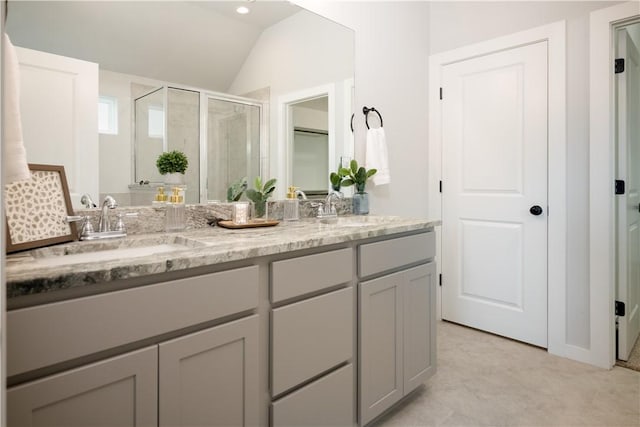 bathroom featuring lofted ceiling, vanity, and an enclosed shower