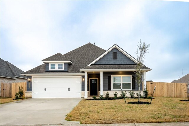 craftsman inspired home featuring a front lawn and a garage