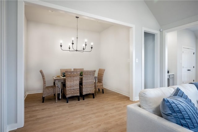 dining space featuring an inviting chandelier, wood-type flooring, and vaulted ceiling