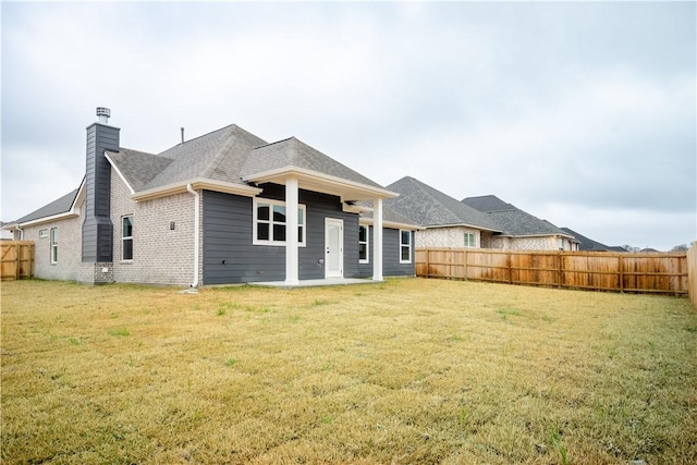 rear view of property with a yard