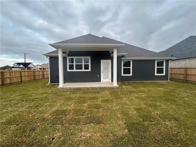 rear view of house featuring a patio area and a lawn