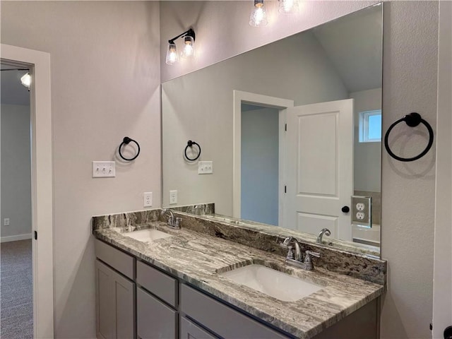 bathroom featuring vanity and lofted ceiling