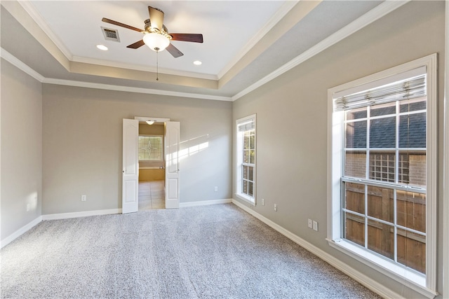 empty room featuring carpet flooring, a tray ceiling, ceiling fan, and ornamental molding