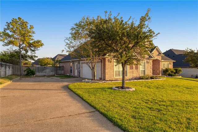 obstructed view of property with a garage and a front lawn