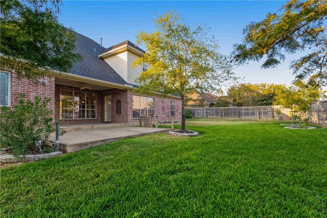 view of yard with ceiling fan and a patio