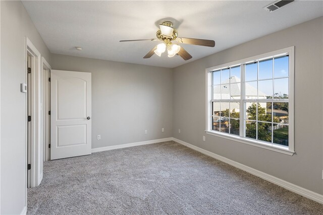 empty room featuring ceiling fan and light colored carpet