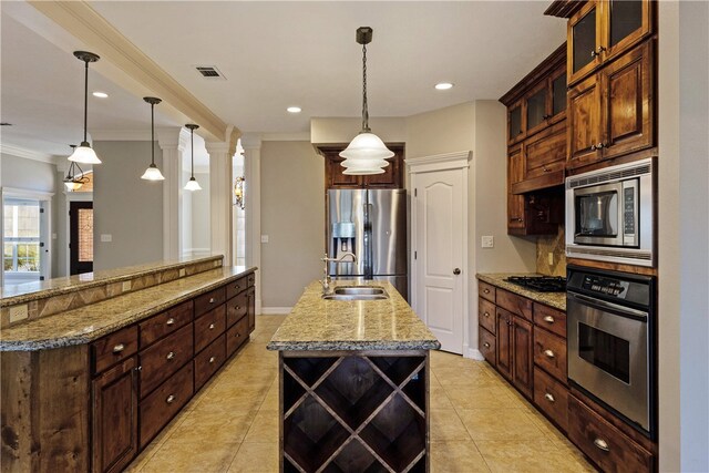 kitchen with a kitchen island with sink, crown molding, hanging light fixtures, light tile patterned floors, and stainless steel appliances