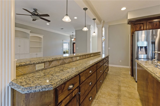 kitchen featuring stainless steel fridge, crown molding, light stone countertops, and decorative light fixtures