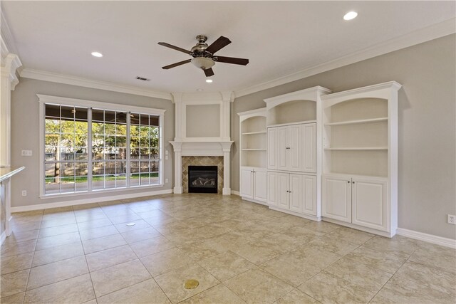 unfurnished living room with ceiling fan, ornamental molding, light tile patterned floors, and built in shelves