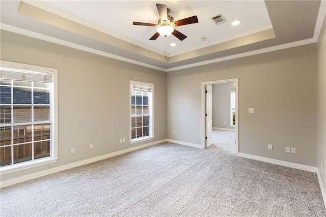 carpeted empty room featuring a tray ceiling, ceiling fan, and ornamental molding