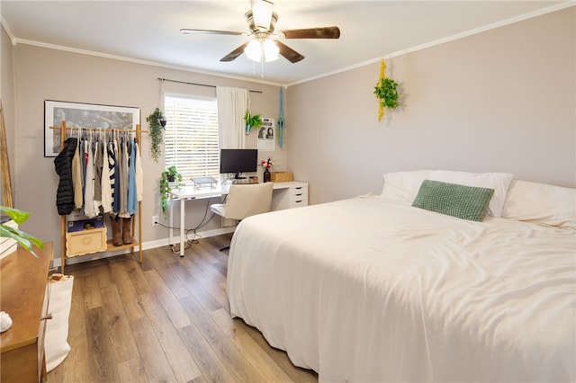 bedroom with light wood-type flooring, ornamental molding, a ceiling fan, a closet, and baseboards