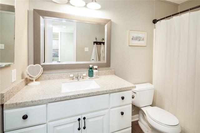 bathroom with curtained shower, toilet, and vanity