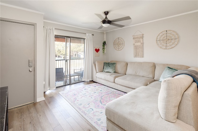 living area with wood finished floors, ornamental molding, and a ceiling fan