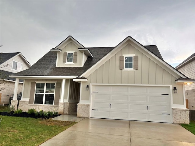 craftsman-style house with a front lawn, roof with shingles, board and batten siding, concrete driveway, and an attached garage