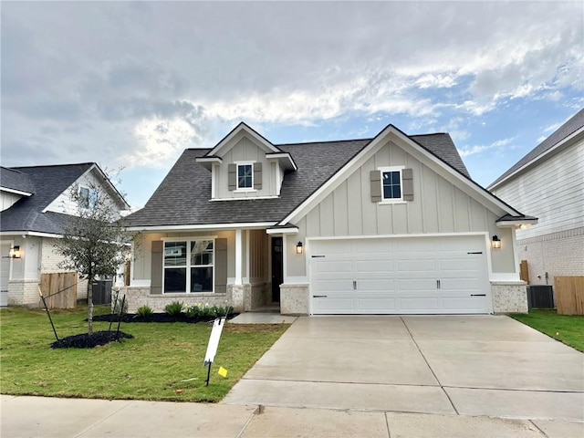 view of front of property featuring driveway, board and batten siding, a front lawn, and fence