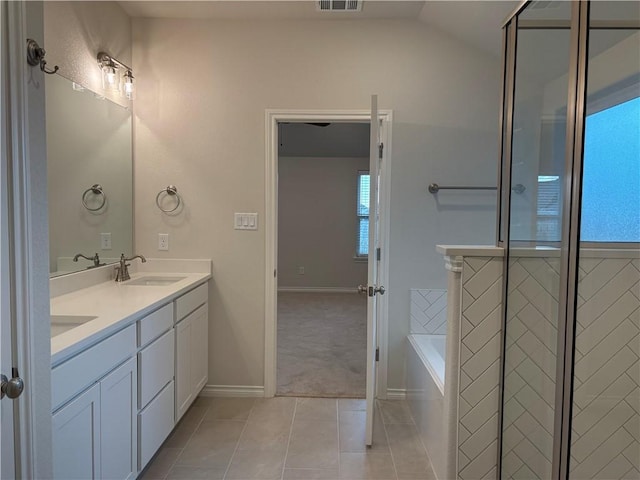 bathroom with vanity, tile patterned flooring, a bathtub, and lofted ceiling