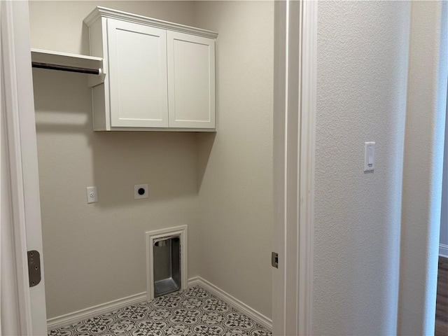 clothes washing area with hookup for an electric dryer, light tile patterned floors, and cabinets