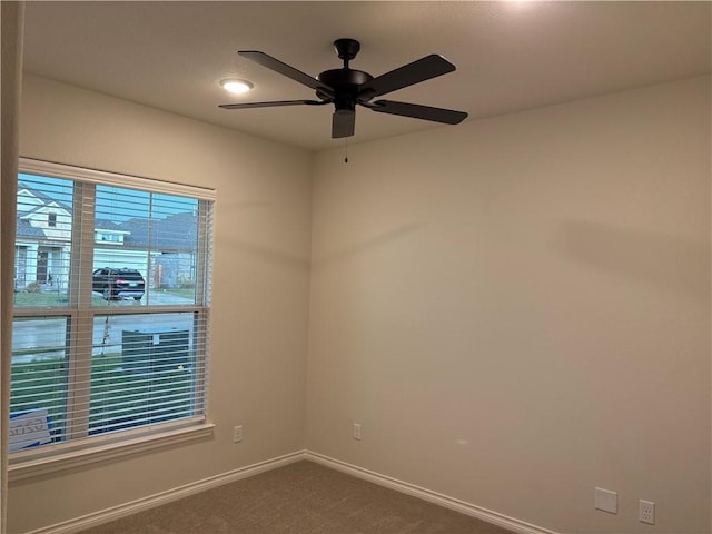 carpeted spare room with ceiling fan