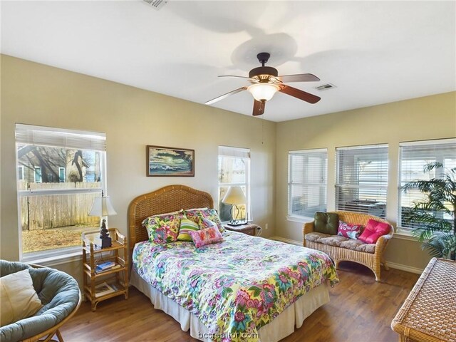 bedroom with multiple windows, ceiling fan, and hardwood / wood-style flooring