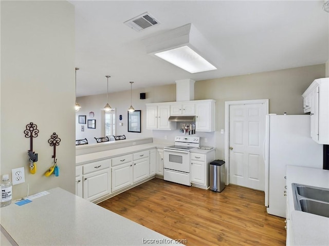 kitchen with pendant lighting, white appliances, wood-type flooring, kitchen peninsula, and white cabinetry