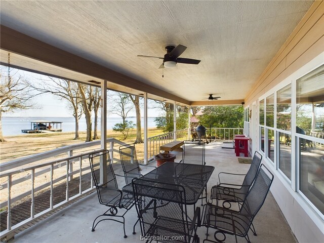 view of patio featuring a water view and ceiling fan