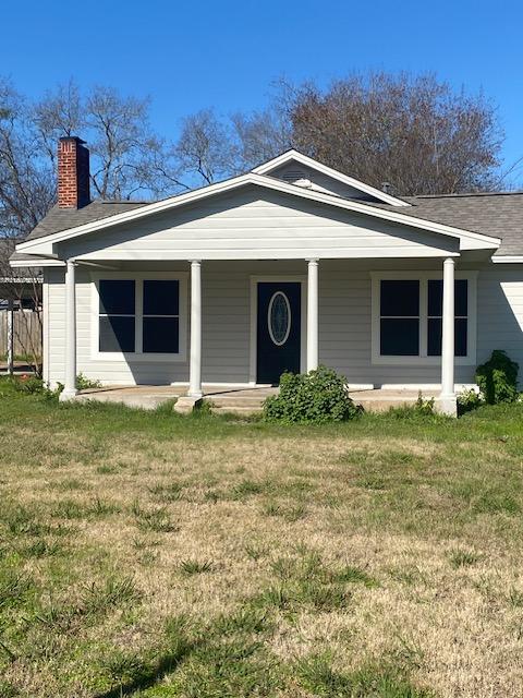 view of front facade with covered porch and a front lawn