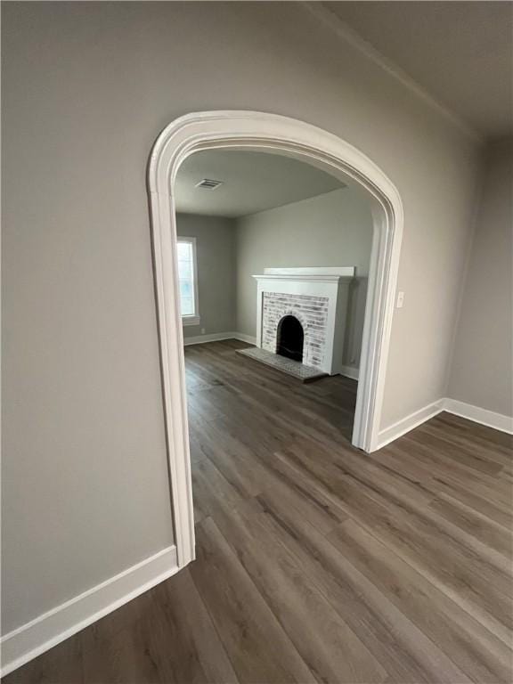 unfurnished living room featuring dark hardwood / wood-style flooring and a fireplace